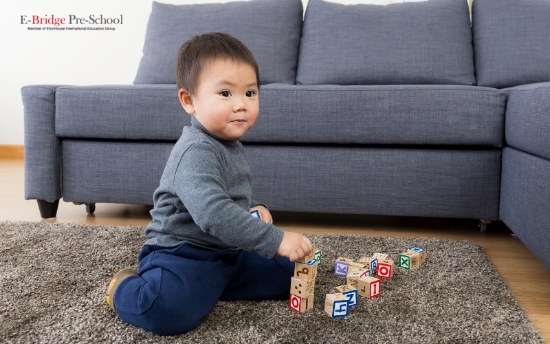 a cute baby playing with his toys-infant care singapore